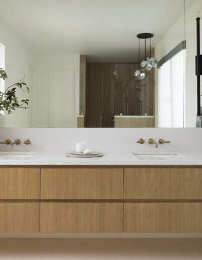 A modern bathroom with wooden cabinets and a large mirror.