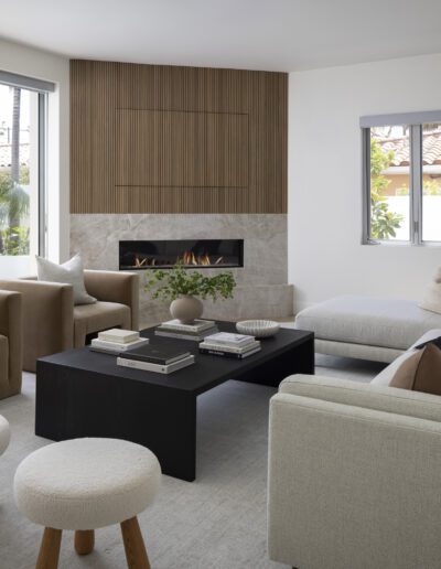 A living room with white furniture and a fireplace.