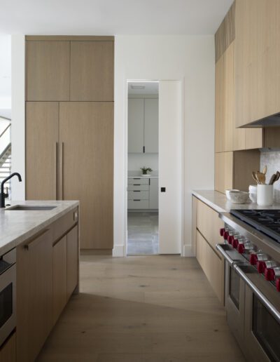 A modern kitchen with wood cabinets and a stove.