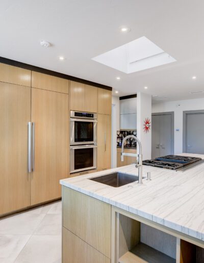 A modern kitchen with marble counter tops and stainless steel appliances.