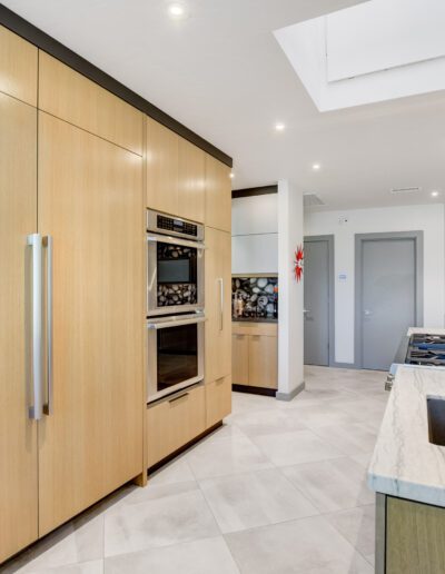 A modern kitchen with wooden cabinets and a skylight.